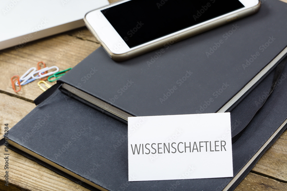 Wissenschaftler, German text for Scientist business card on office desktop with electronic devices Wissenschaftler, German text for Scientist business card on office desktop with electronic devices