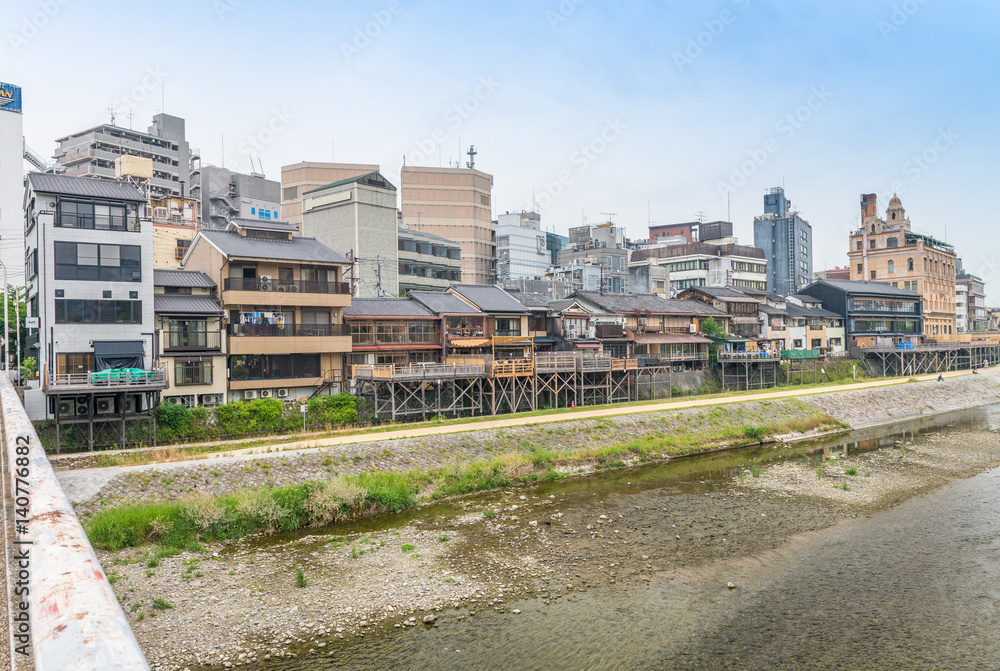 KYOTO, JAPAN - MAY 28, 2016: City buildings along the river. Kyoto us a famous city destination in Japan KYOTO, JAPAN - MAY 28, 2016: City buildings along the river. Kyoto us a famous city destination in Japan
