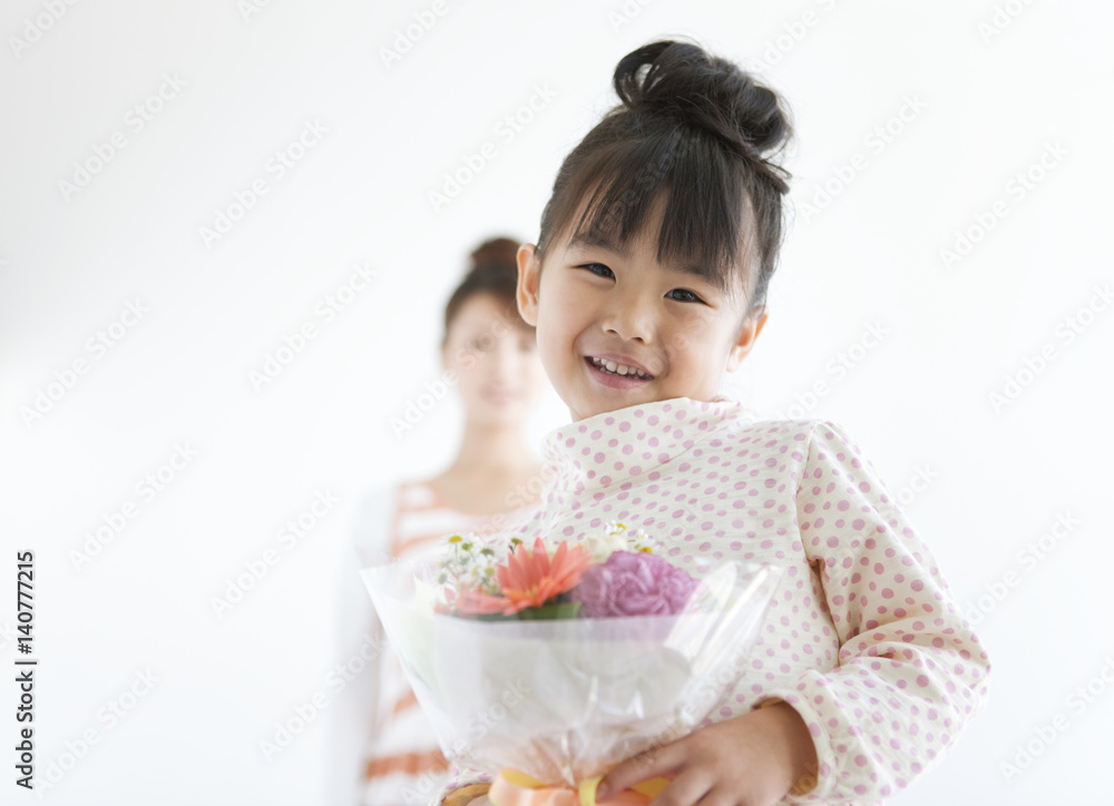 Portrait of girl with mother holding flower bouquet, white background, differential focus Portrait of girl with mother holding flower bouquet, white background, differential focus
