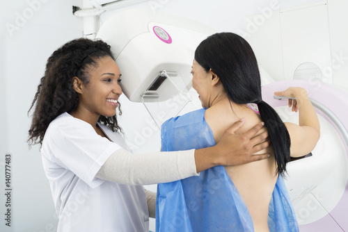 Happy Doctor Assisting Woman Undergoing Mammogram X-ray Test photo