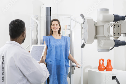 Fototapeta Naklejka Na Ścianę i Meble -  Male Doctor Taking X-ray Of Female Patient In Hospital