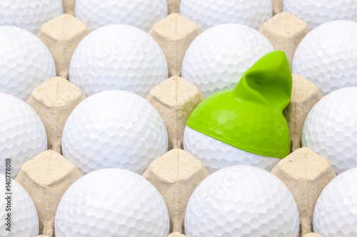 White golf balls in the box for eggs. Golf ball with funny cap.