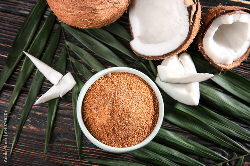 Bowl of brown sugar and coconut on wooden background