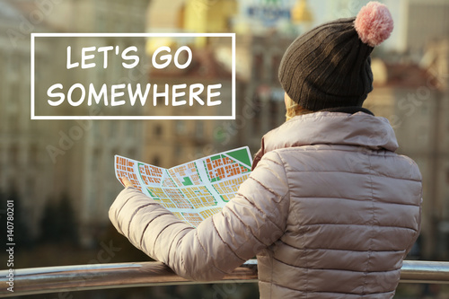 Young woman holding map on ...