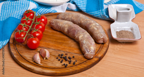 Sausages in a natural shell and tomatoes on a table