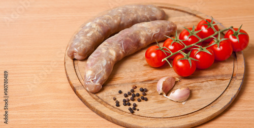 Sausages in a natural shell and tomatoes on a table