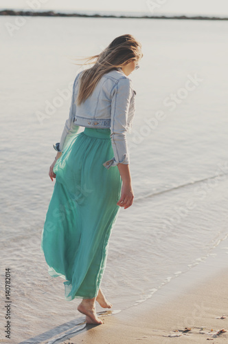 Amazing young woman in green dress near the sea