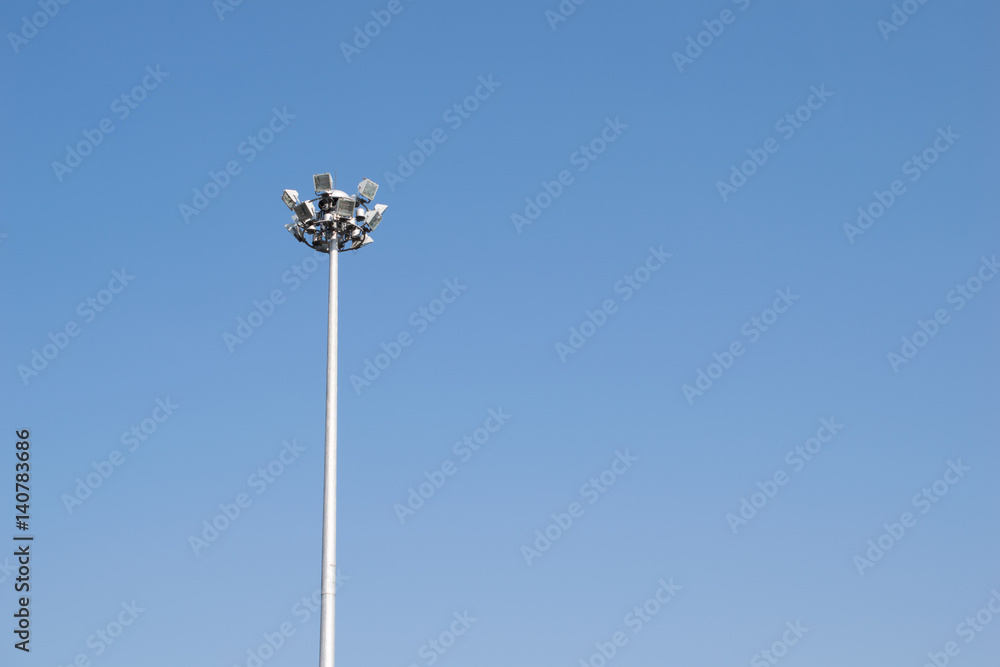 Lonely stadium light or lamp post with Union of light bulb standing alone with clould and blue sky. Lonely stadium light or lamp post with Union of light bulb standing alone with clould and blue sky.