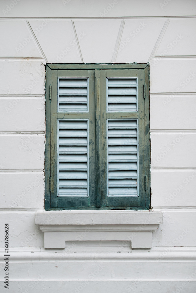 Fototapeta premium Old green wood window and white wall of building.