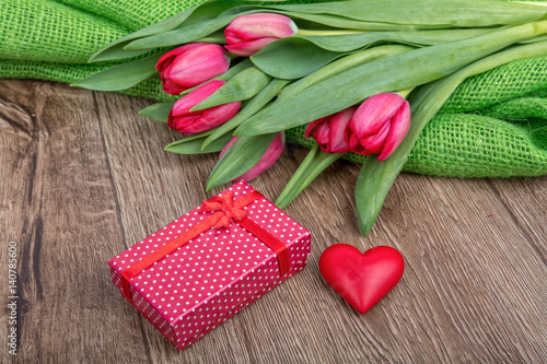 Fototapeta Naklejka Na Ścianę i Meble -  Red tulips, heart and gift on a wooden background