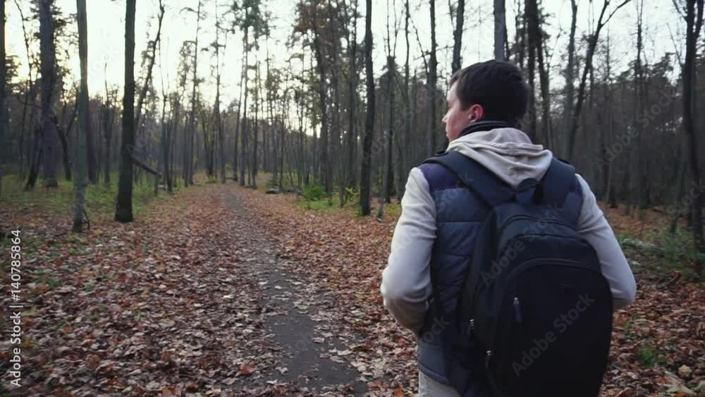 Adult man walks along the autumnal forest to get new impressions of nature. Adult man walks along the autumnal forest to get new impressions of nature.