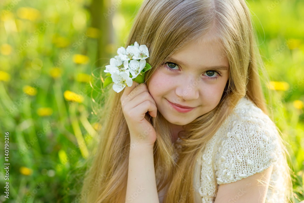 A beautiful little girl runs through a flowering garden in the spring A beautiful little girl runs through a flowering garden in the spring