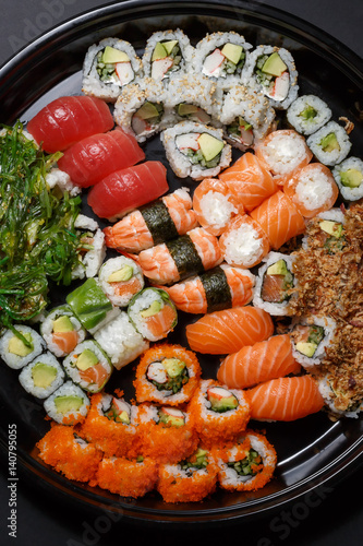 A large set of sushi and rolls view from above. A lot of food in one plate. Dishes from raw fish Japanese food