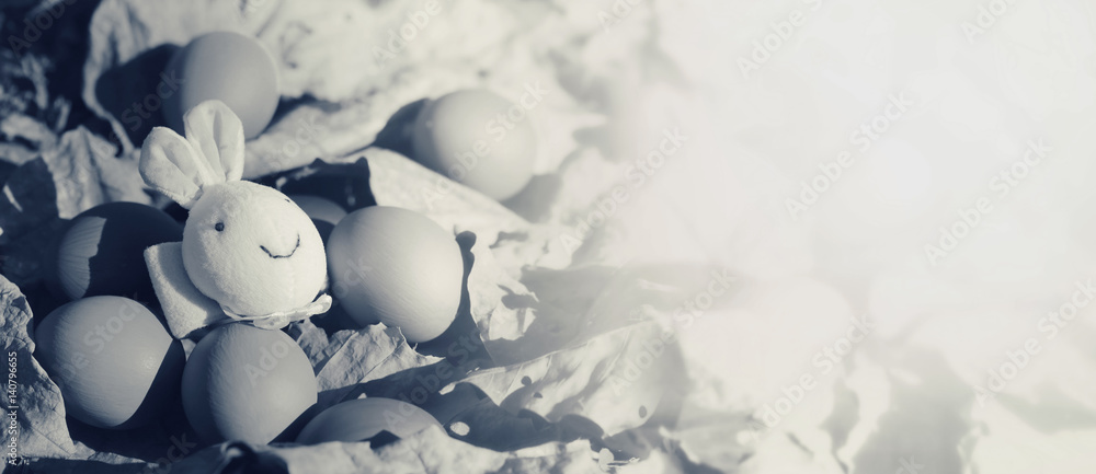 Colorful Easter eggs and rabbit on dry leaves with vintage color.Easter concept background with copy-space for texts. Colorful Easter eggs and rabbit on dry leaves with vintage color.Easter concept background with copy-space for texts.