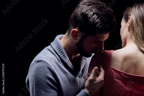 Man kissing his girlfriend's shoulder