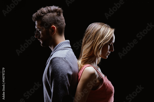 Sad couple standing back to back