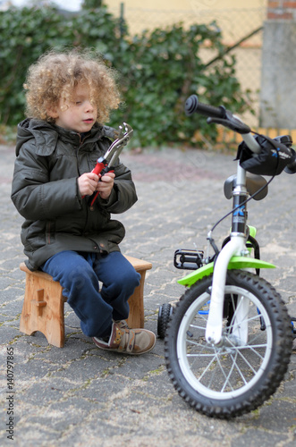 Kleinkind repariert baut bastelt an seinem Fahrrad