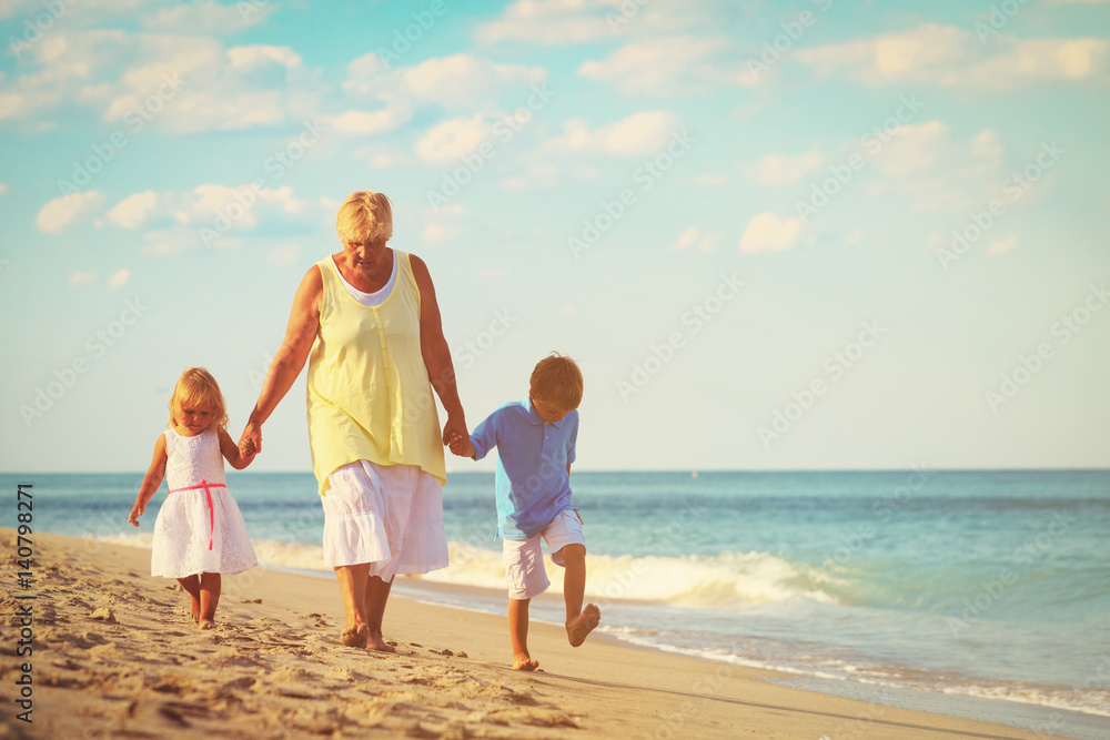 grandmother with kids- little boy and girl- at beach