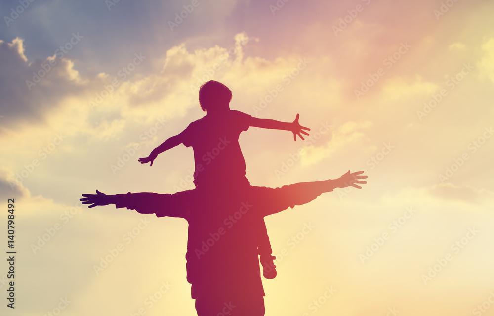 father and son play on sunset sky father and son play on sunset sky