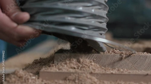 In the woodworkers shop the cnc drill is drilling. Vacuum cleaner absorb wood chips
Slowmotion. close-up
