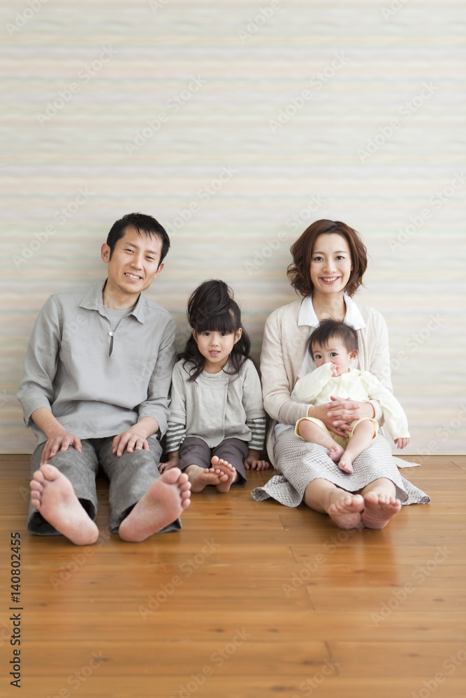 Portrait of family sitting on hardwood floor Portrait of family sitting on hardwood floor