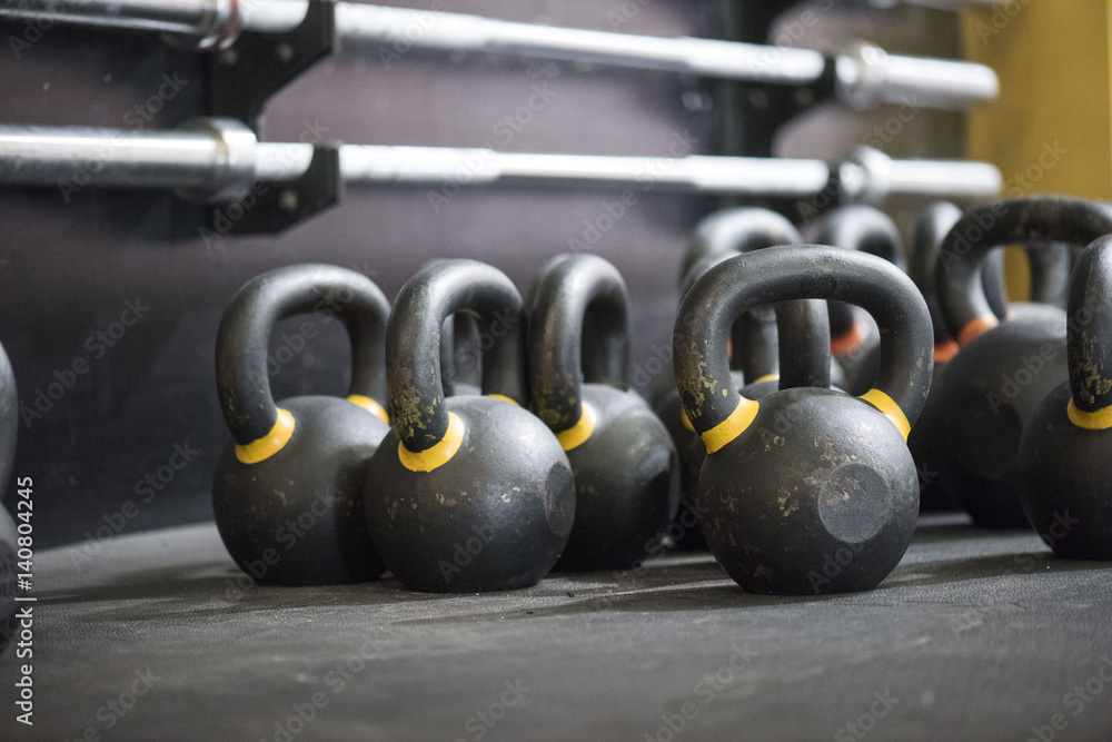 Large grouping of kettlebells and barbells in a cross fit gym with a blurred background Large grouping of kettlebells and barbells in a cross fit gym with a blurred background