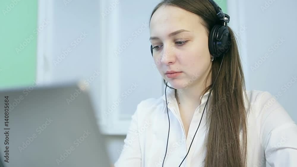 Beautiful girl with headphones working at her laptop. Beautiful girl with headphones working at her laptop.