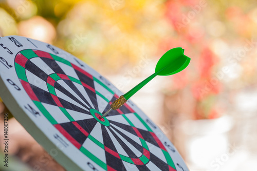 green dart on dart board with clor background photo