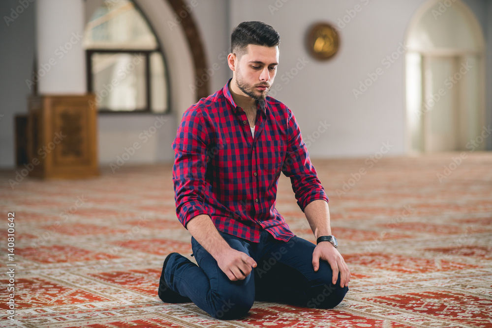 Fototapeta premium Humble Muslim praying while kneeling