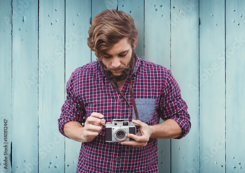 Composite image of Man with camera against blue wood panel photo