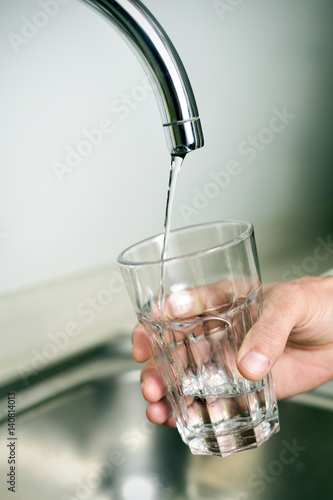 man filling a glass of tap water