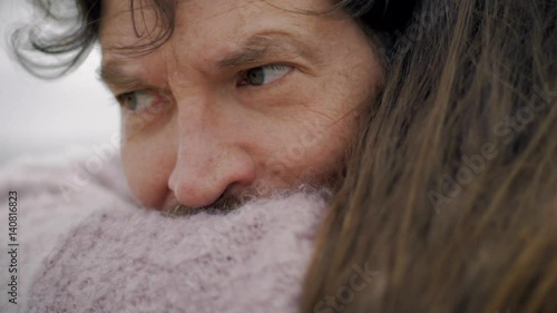 Sad man almost crying hugging and holding woman he loves closeup