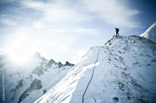 Man climbing to the snow peak of the Massif du Sancy © Mickael
