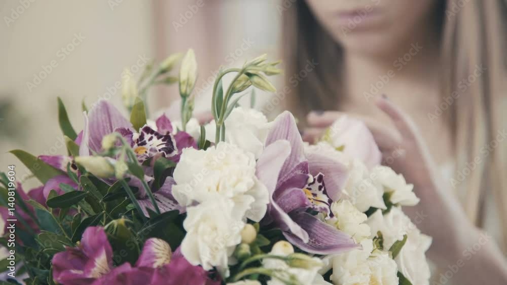 A beautiful girl florist makes a flower arrangement. Female florist making beautiful bouquet at flower shop. Florist. Flower shop. Drawing up bouquets. The process of creating a floral composition. A beautiful girl florist makes a flower arrangement. Female florist making beautiful bouquet at flower shop. Florist. Flower shop. Drawing up bouquets. The process of creating a floral composition.