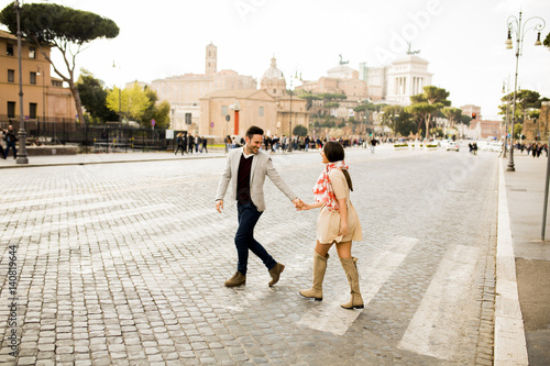 Photography Casual young couple holding hands walking in Rome, Italy, Europe