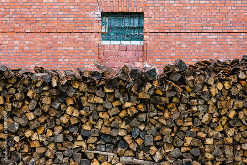 firewood stacked on the red brick wall