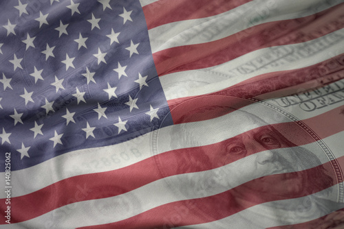 colorful waving national flag of united states of america on a american dollar money background. finance concept