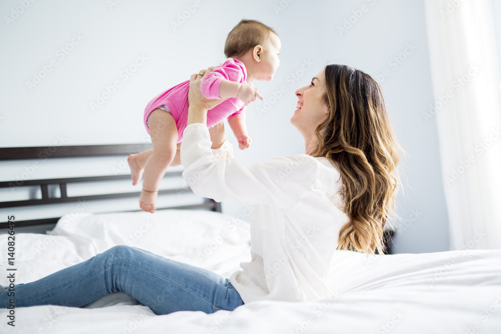 Mother and baby child on a white bed. Mother and baby child on a white bed.