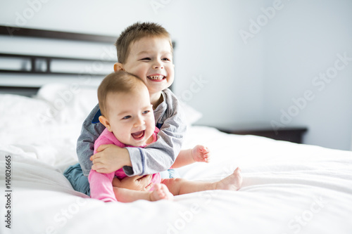 baby and his brother on bed photo