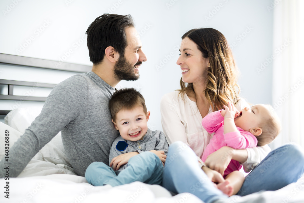 four peoples family on a white bed. four peoples family on a white bed.