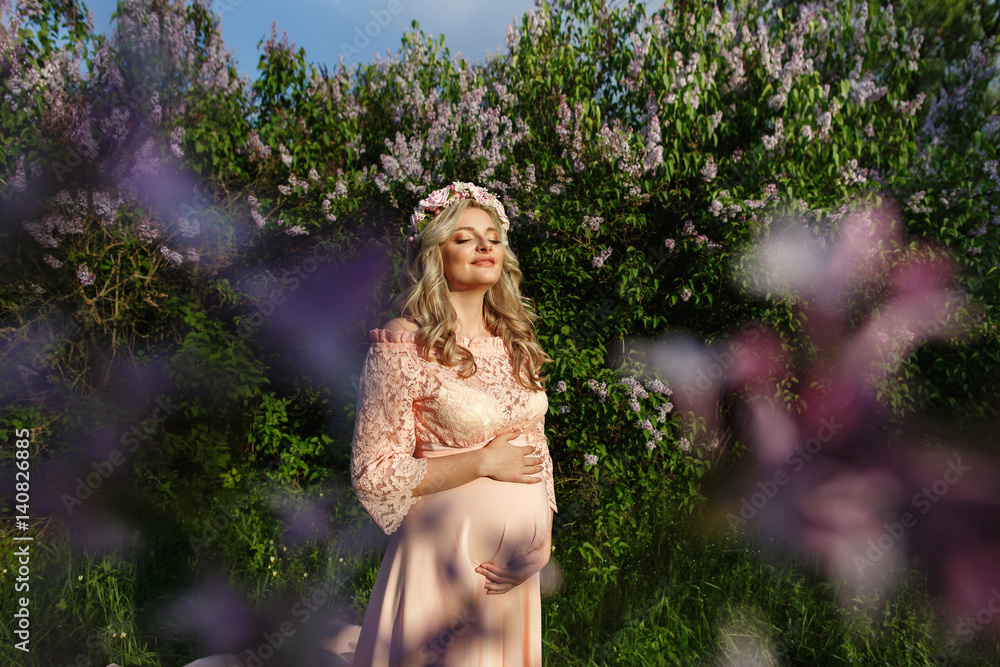 Naklejka premium Relax of pregnant woman, young mother smiling in spring garden