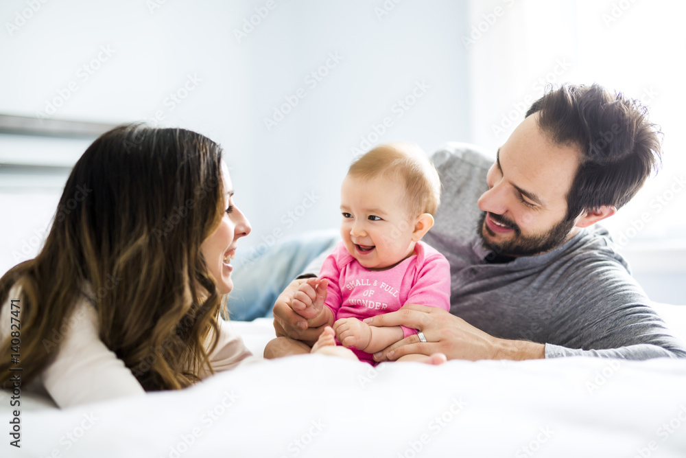 Mother father and baby child on a white bed. Mother father and baby child on a white bed.