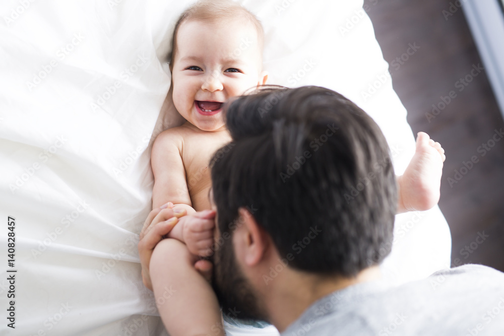 happy father playing with adorable baby in bedroom happy father playing with adorable baby in bedroom