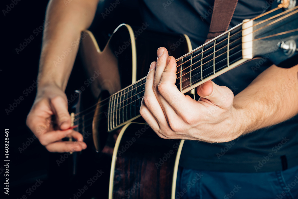 Obraz premium Female hand playing on acoustic guitar. Close-up.