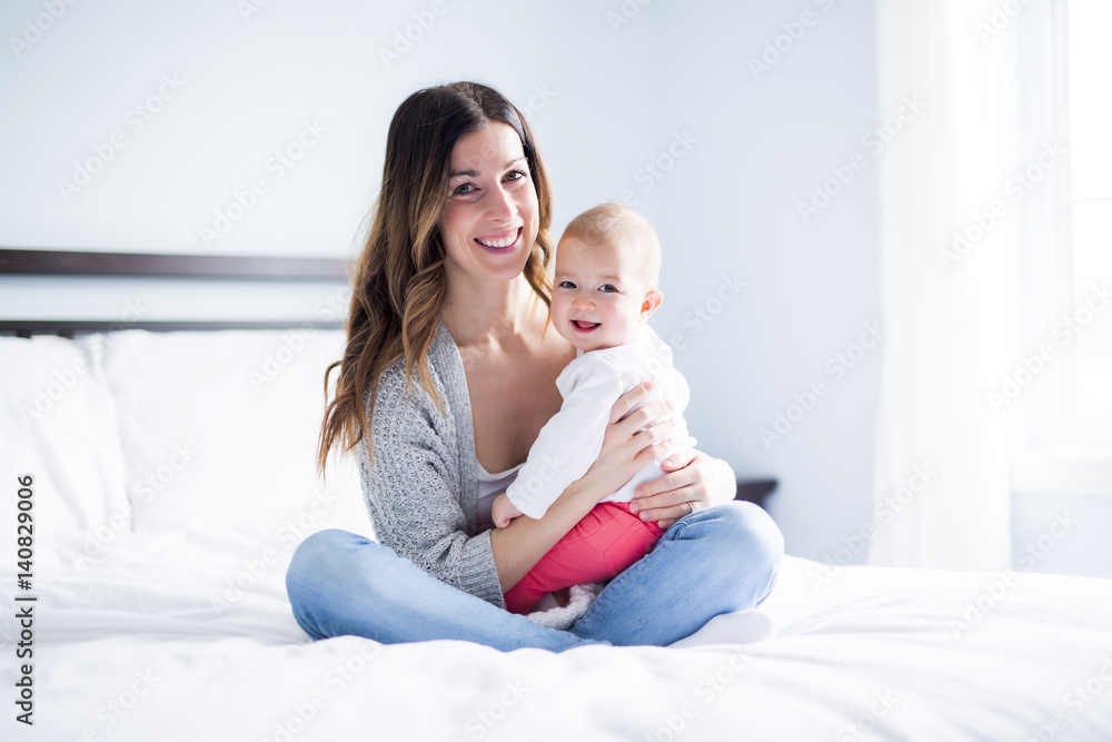 Mother and baby child on a white bed. Mother and baby child on a white bed.