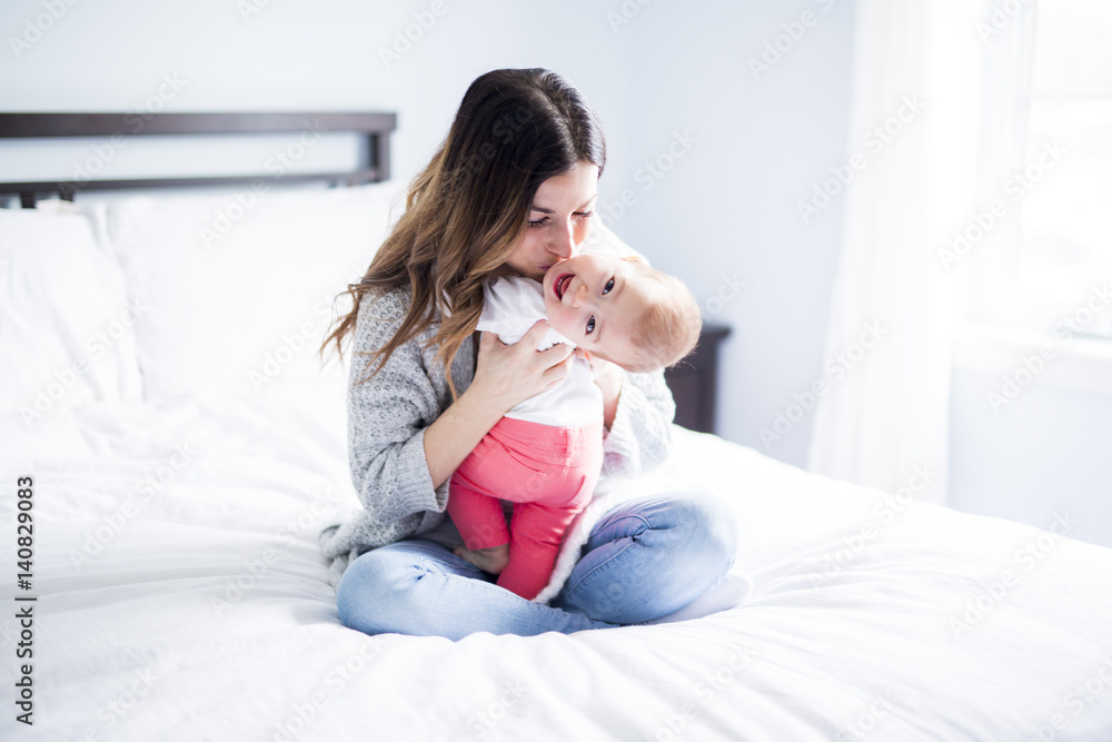 Mother and baby child on a white bed. Mother and baby child on a white bed.