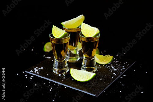 Strong alcohol drinks. Tequila shots with salt and lime slices.