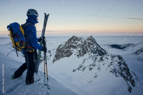 skier on top of the mountain admiring the sunset