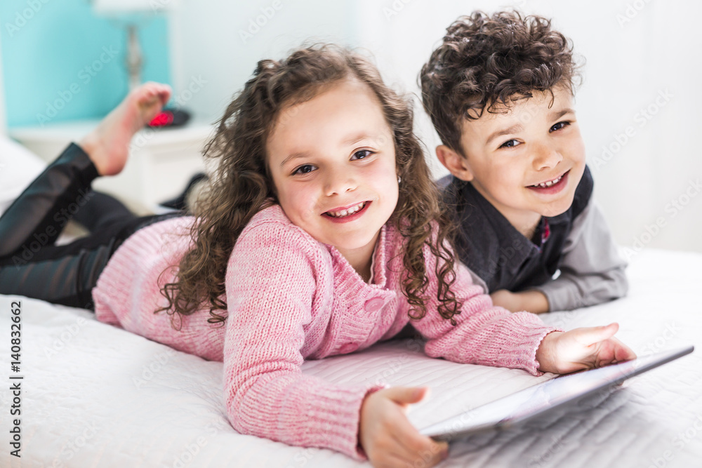 Cute brother and sister enjoying tablet at home Cute brother and sister enjoying tablet at home