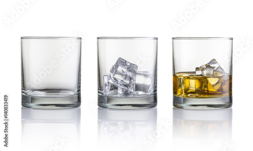 Empty glass, glass with ice cubes and glass with whiskey and ice cubes. Isolated on white background